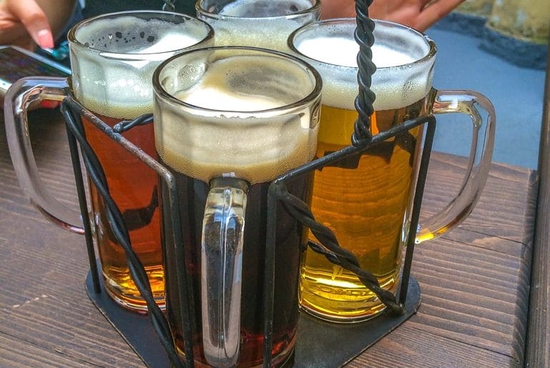 Vier Biergläser auf Holztisch in Prag