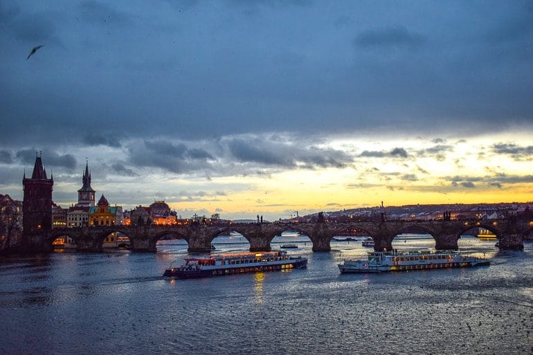 Boote auf Fluss mit Brücke bei Nacht Prag Sehenswürdigkeiten