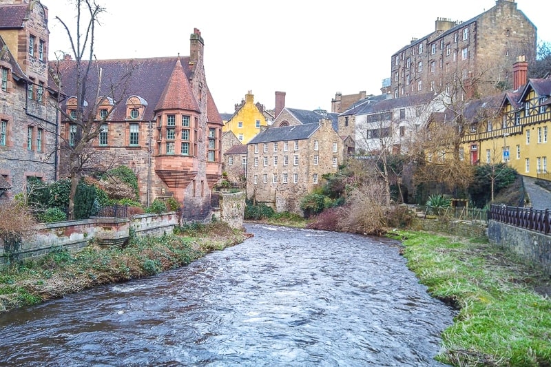 river flowing through historic coloured houses in edinburgh
