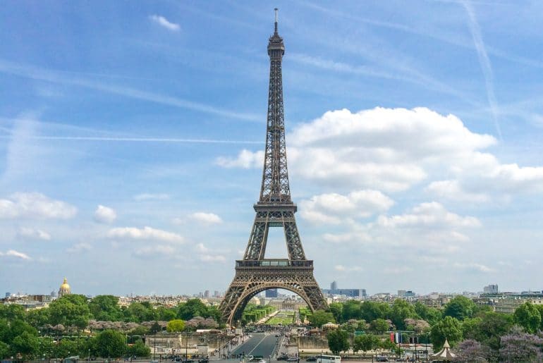 eiffel tower with blue sky and green trees europe trip itinerary