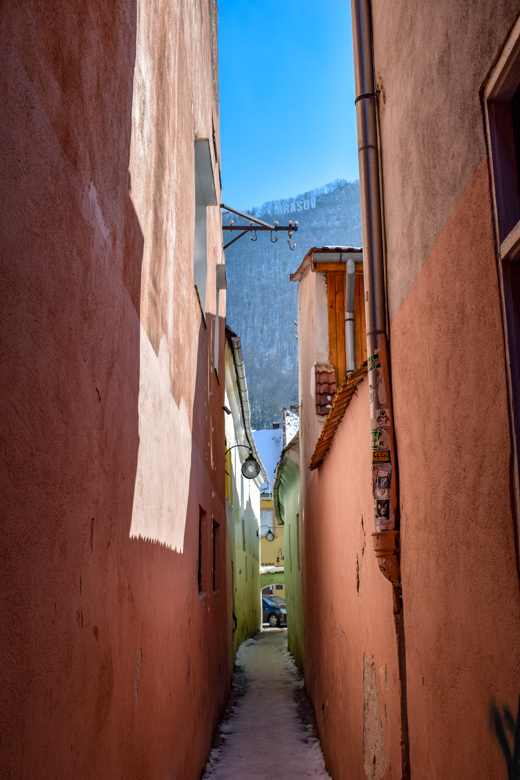 narrow street with red walls brasov romania