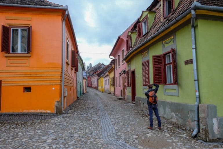 colourful houses and cobblestone street with boy taking photo