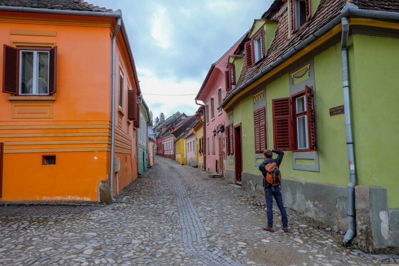colourful houses and cobblestone street with boy taking photo