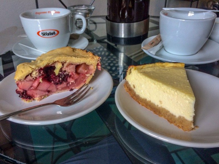 cheesecake and pie with coffee mugs on table