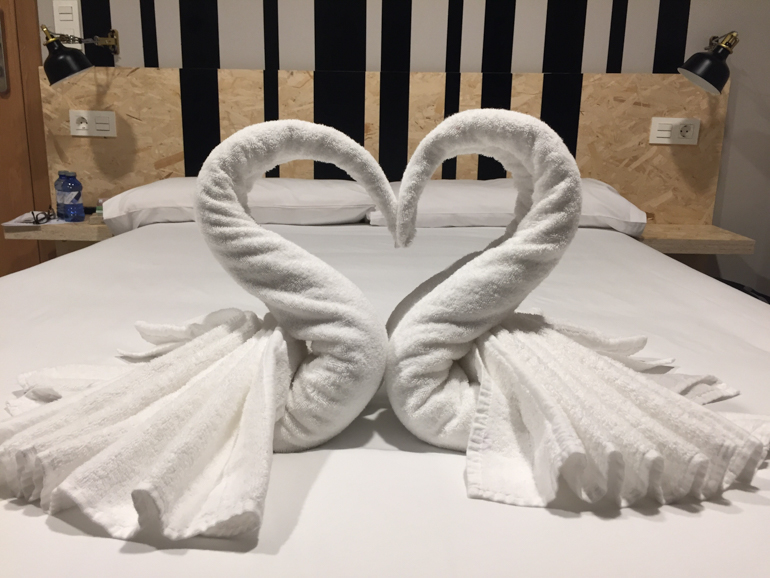 white towel swans on white bed