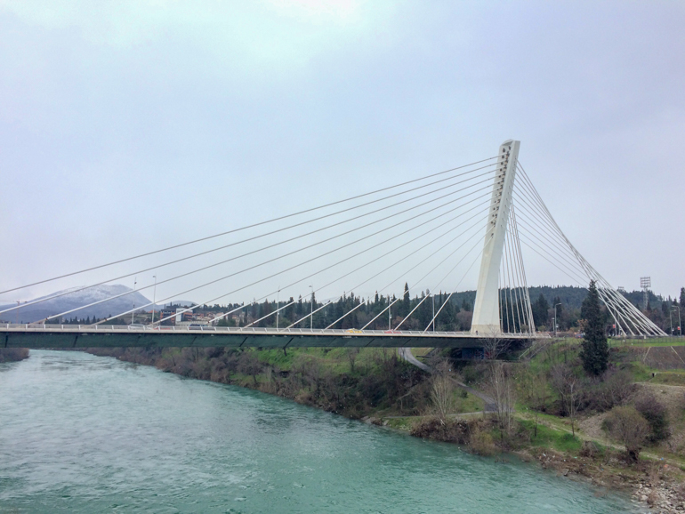 white steel bridge over blue river podgorica