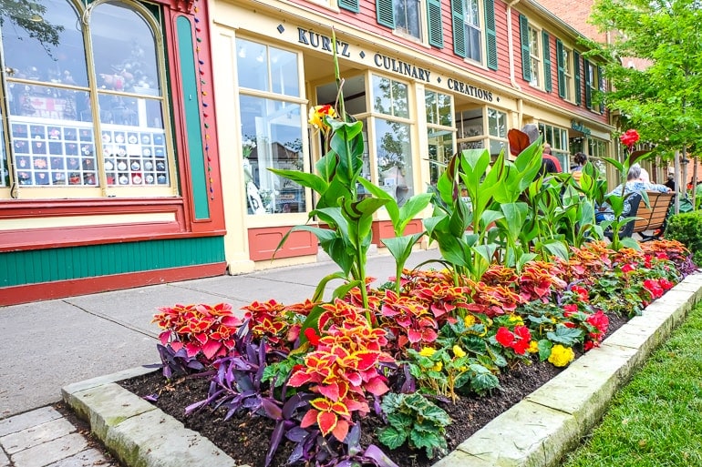 colourful gardens with sidewalk and stores behind in niagara on the lake