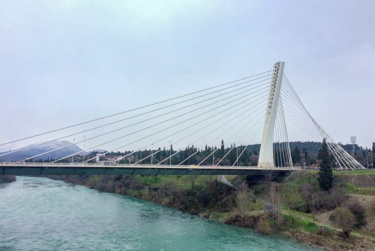 white steel bridge over blue river podgorica