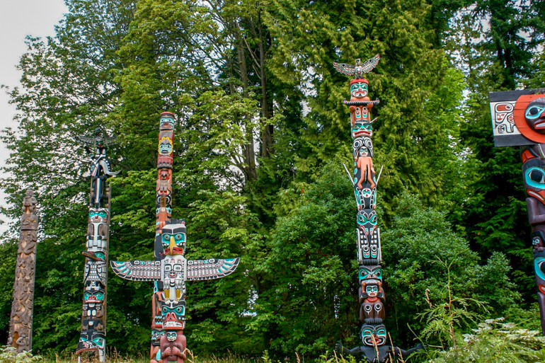 totem poles with green trees behind vancouver itinerary