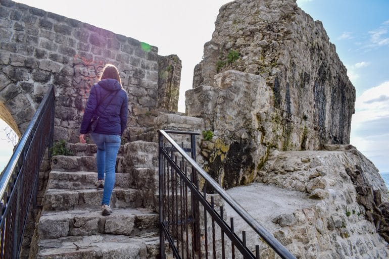 girl walking up stairs to ruins in herceg novi