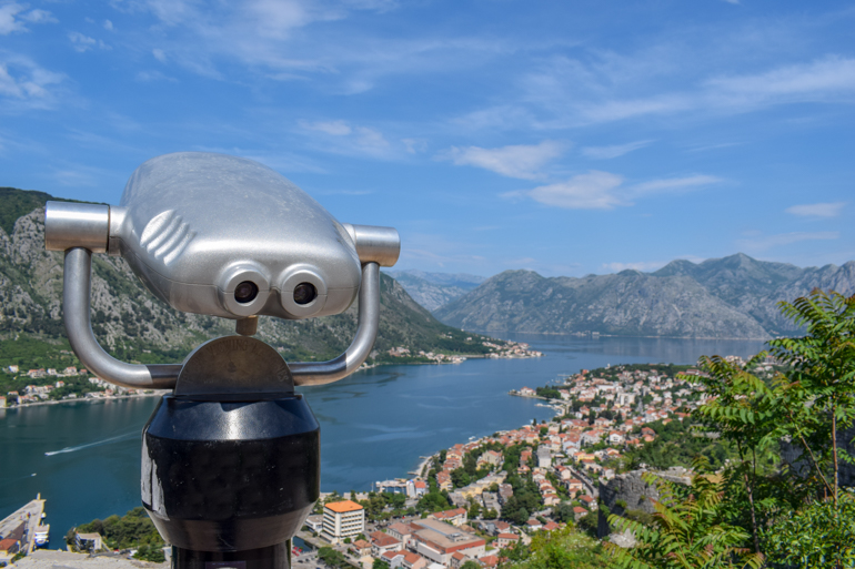 view finder overlooking bay of kotor in montenegro with blue sky above.