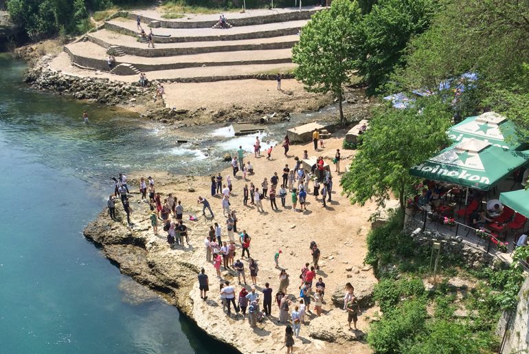 Menschen schießen Fotos beim blauen Fluss in Mostar
