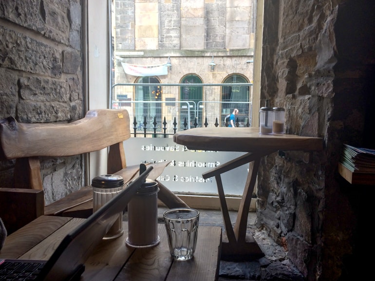 wooden bench and table with bright window at coffee shop in edinburgh black medicine