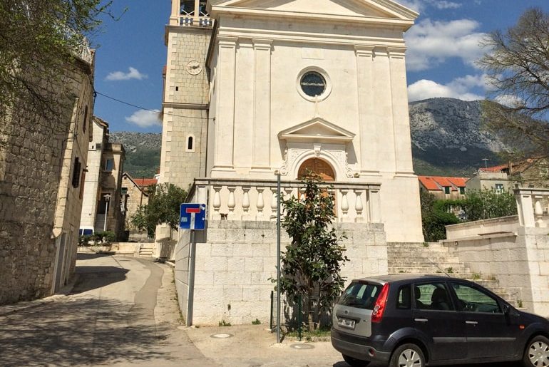 car in front of stone church on croatia road trip