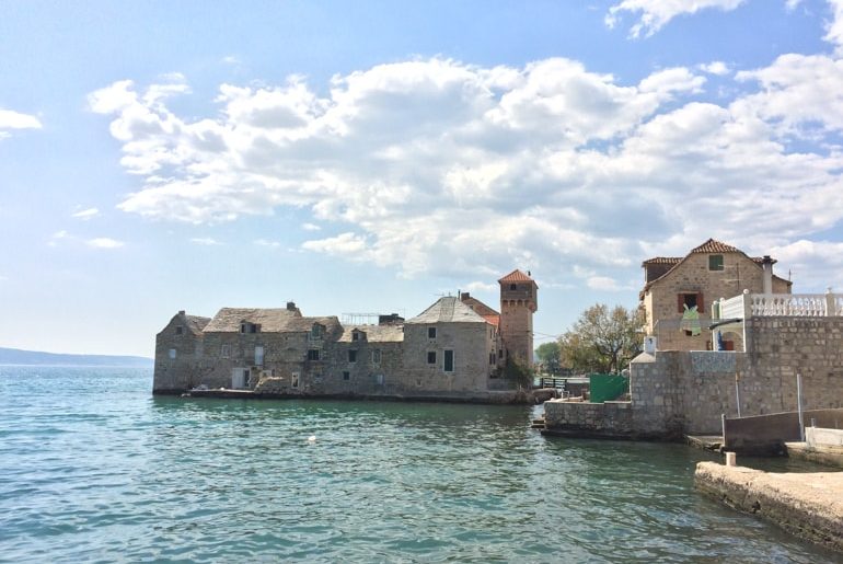 old town tower on island with blue water around in croatia road trip