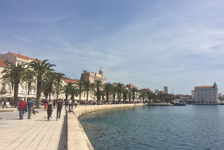 walkway with shoreline and palm trees in split croatia road trip