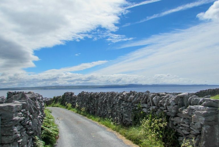 Straße mit Steinwall und blauem Himmel Sehenswürdigkeiten Irland