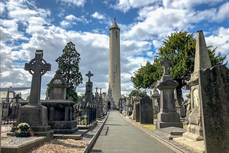 tombstones in cemetery with straight path and tower ahead ireland travel tips