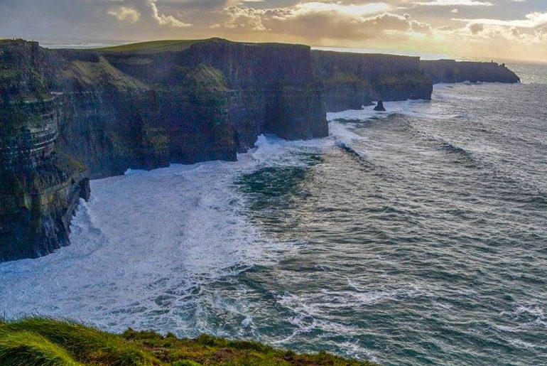 cliffs with water below and sunset above ireland travel tips