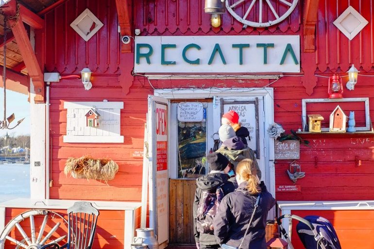 Rote Fasade mit Menschenmenge vor Café Ein Tag in Helsinki Finnland