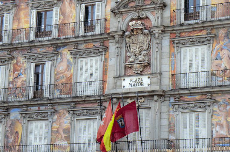 Plaza Mayor mit bunter Fasade und Flaggen Sehenwürdigkeit Madrid
