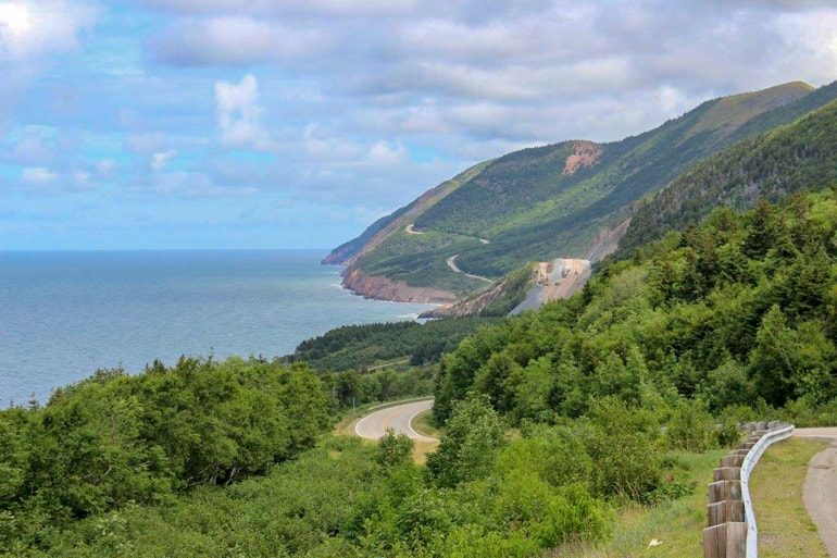 green rolling coast with highway running through cabot trail canada sightseeing