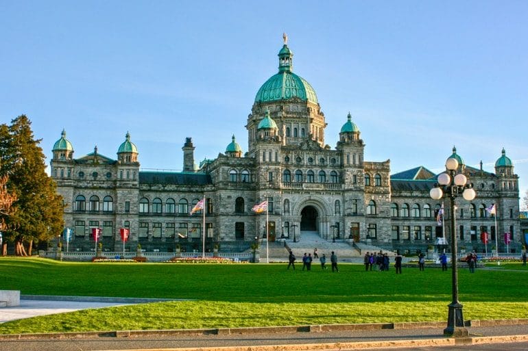 victoria parliament building with green lawn and green dome canada sightseeing