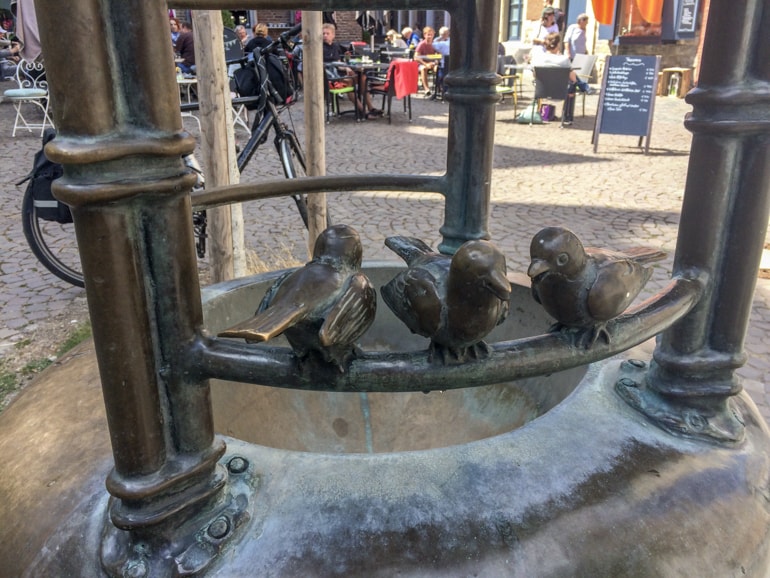 brass bird statues on fountain in german old town.
