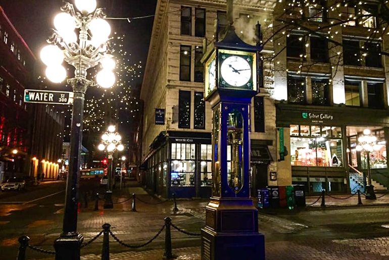 alte blaue Dampfuhr in Gastown bei Nacht mit heller Straßenlaterne daneben in Vancouver