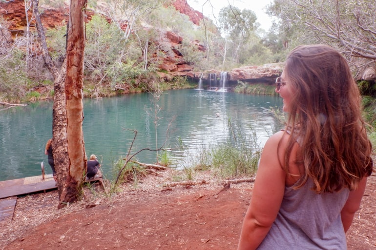 Frau in Karijini National Park mit Wasser im Hintergrund Australien