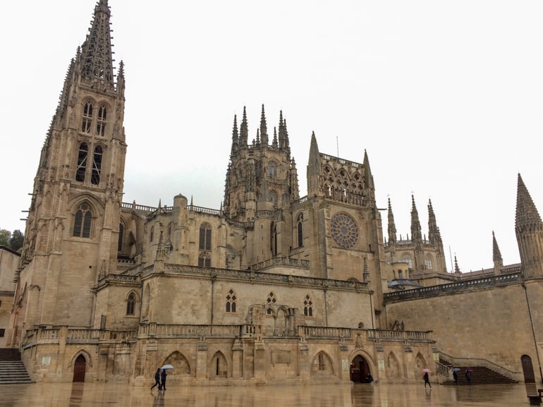 tan stone cathedral seen in the rain in burgos spain.