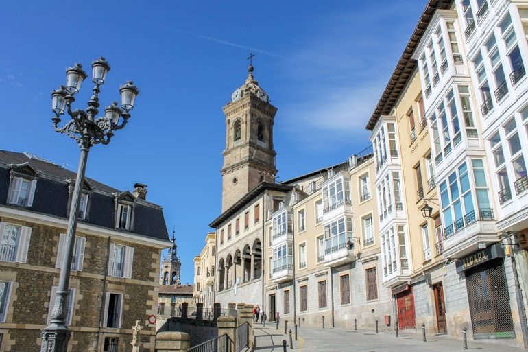 white and coloured buildings with tower in vitoria-gasteiz spain itinerary