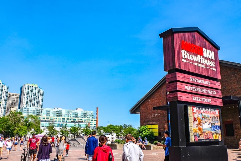 red brewery sign at lake front with people behind harbourfront toronto attractions