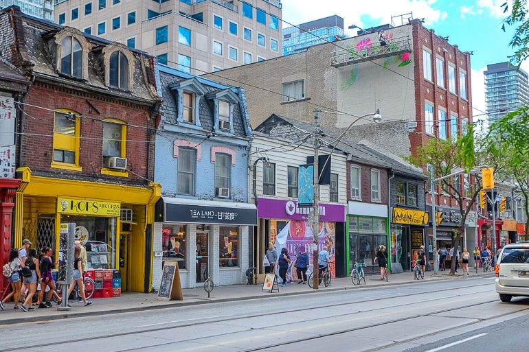 Bunte Läden mit Straße im Vordergrund Queen Street West Toronto Kanaada