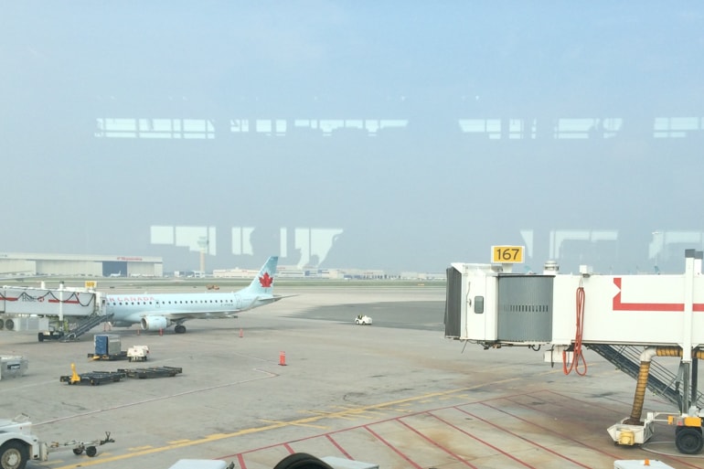 Flugzeuge und Tunnel am Flughafen durch das Fenster fotografiert.