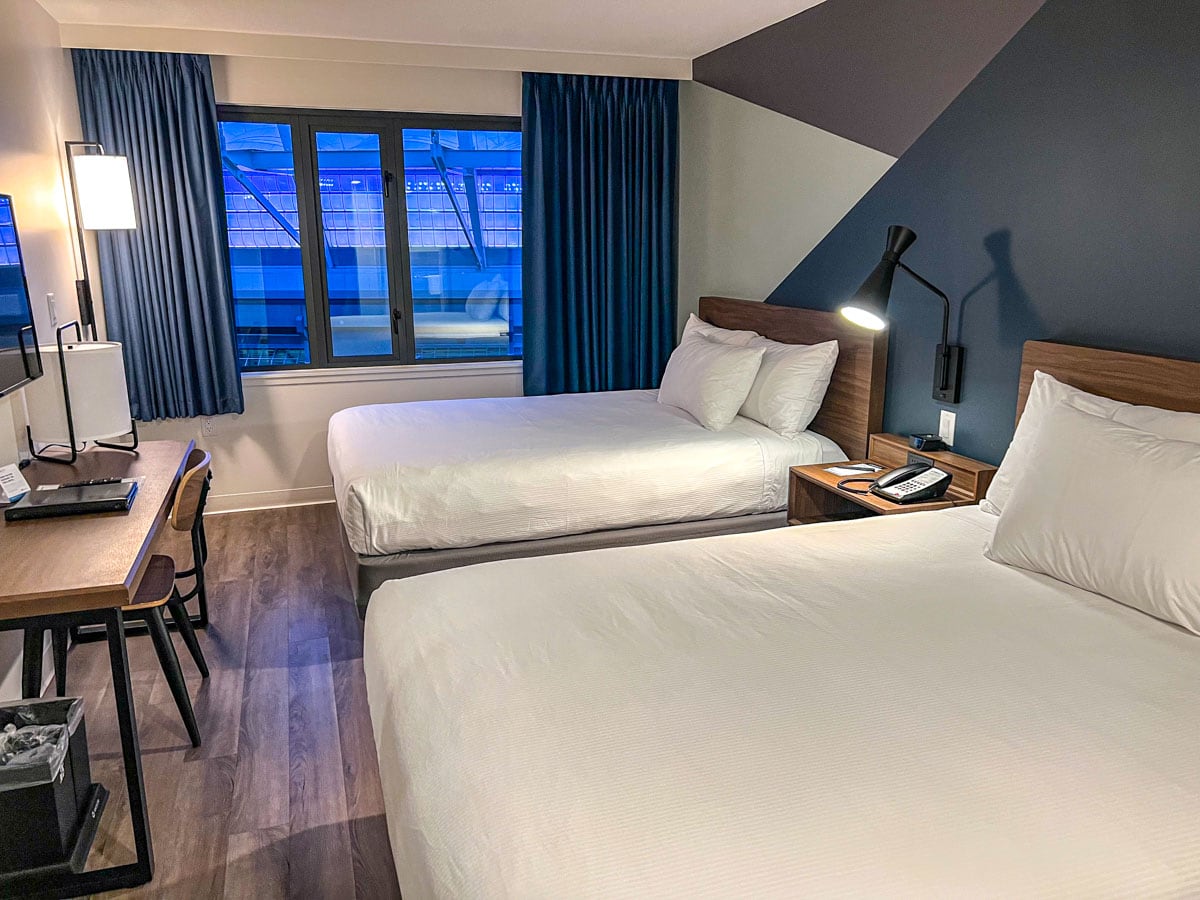 Zwei gemachte Betten mit weißen Laken in einem schönen Hotelzimmer in Vancouver.