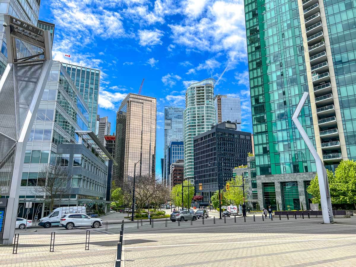 Viele hohe Glasgebäude in der Innenstadt von Vancouver mit blauem Himmel darüber.