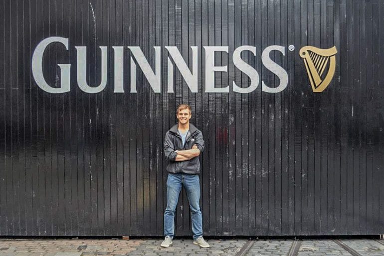 man in front of black guinness doors things to do in dublin