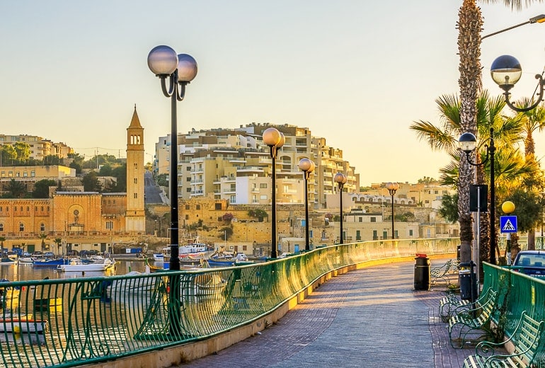 Promenade entlang des Hafens mit Gebäuden im Hintergrund in Marsaskala, Malta

seaside sidewalk along harbourfront with boats and light posts in marsaskala malta