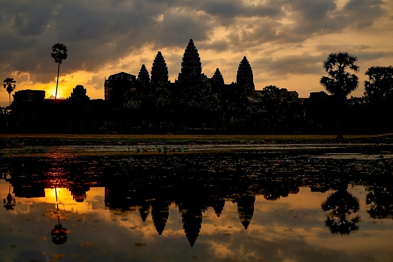 Tempel mit Wasser im Vordergrund und Sonnenaufgang Angkor Wat