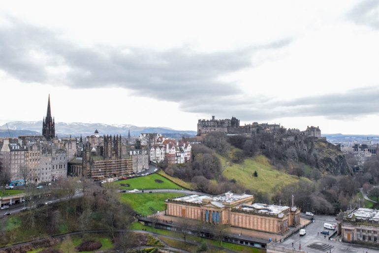Schloss und grüne Gärten mit grauem Himmel Edinburgh Winter