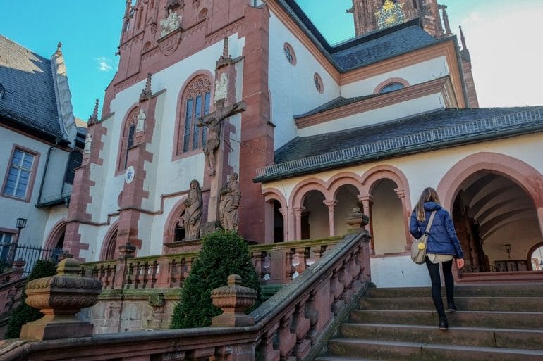 girl climbing stairs to decorated church exterior things to do in aschaffenburg Basilica of St. Peter and Alexander