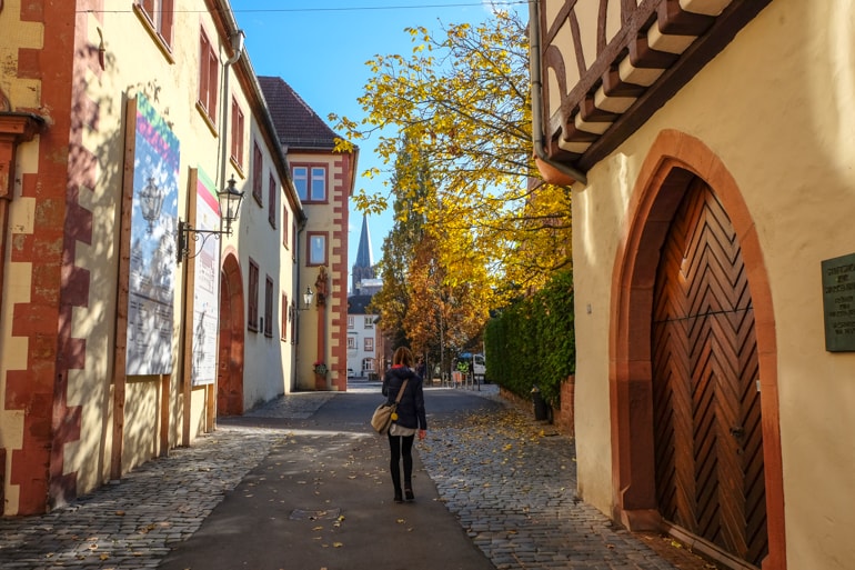 Frau läuft durch bunte Altstadt mit Fachwerkhäusern Aschaffenburg Sehenswürdigkeiten