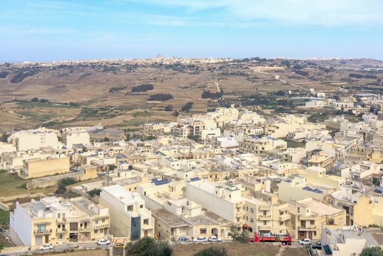 Steingebäude und Straßen von oben mit Autos und Bus auf den Straßen Gozo Malta