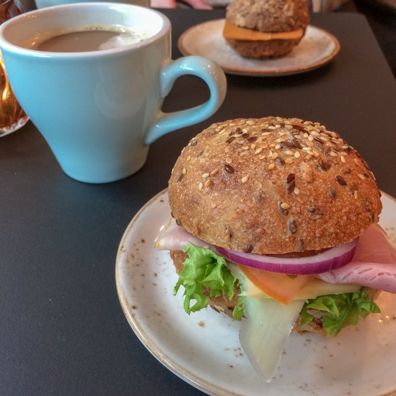 small sandwich on bun with coffee mug things to do in oslo norway
