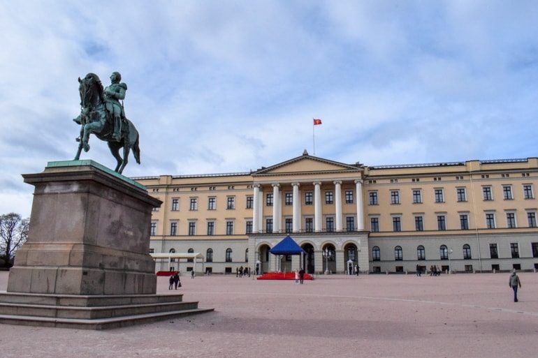 Gelber Palast mit Statue im Vordergrund Oslo Norwegen
