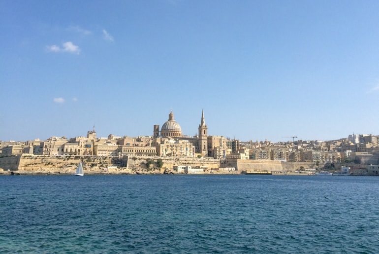 Große Kirchen zwischen kleineren Gebäuden und blauem Wasser Valletta Malta