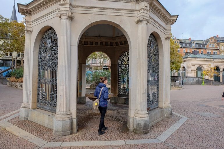 girl in blue jacket standing in entrance to arched stone tower things to do in wiesbaden
