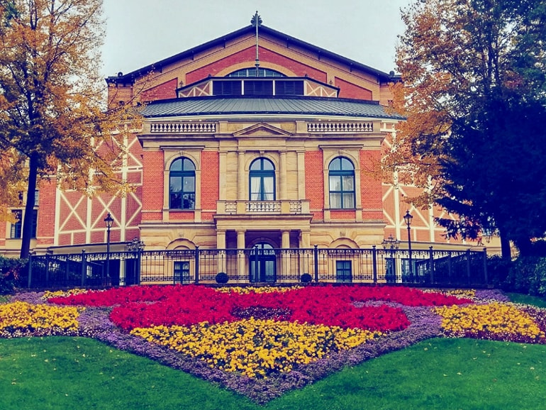 Haus mit roter Fasade und blumen und gras im Vordergrund Bayreuth schöne Städte