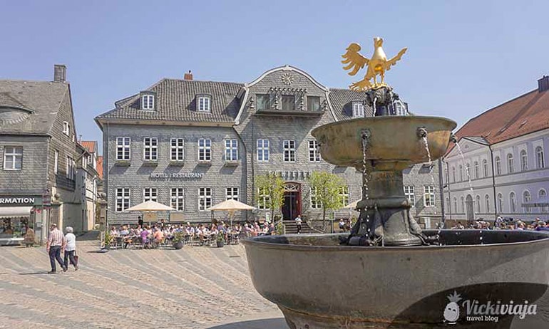 Springbrunnen mit goldenem Vogel und Gebäuden im Hintergrund Goslar schöne Städte
